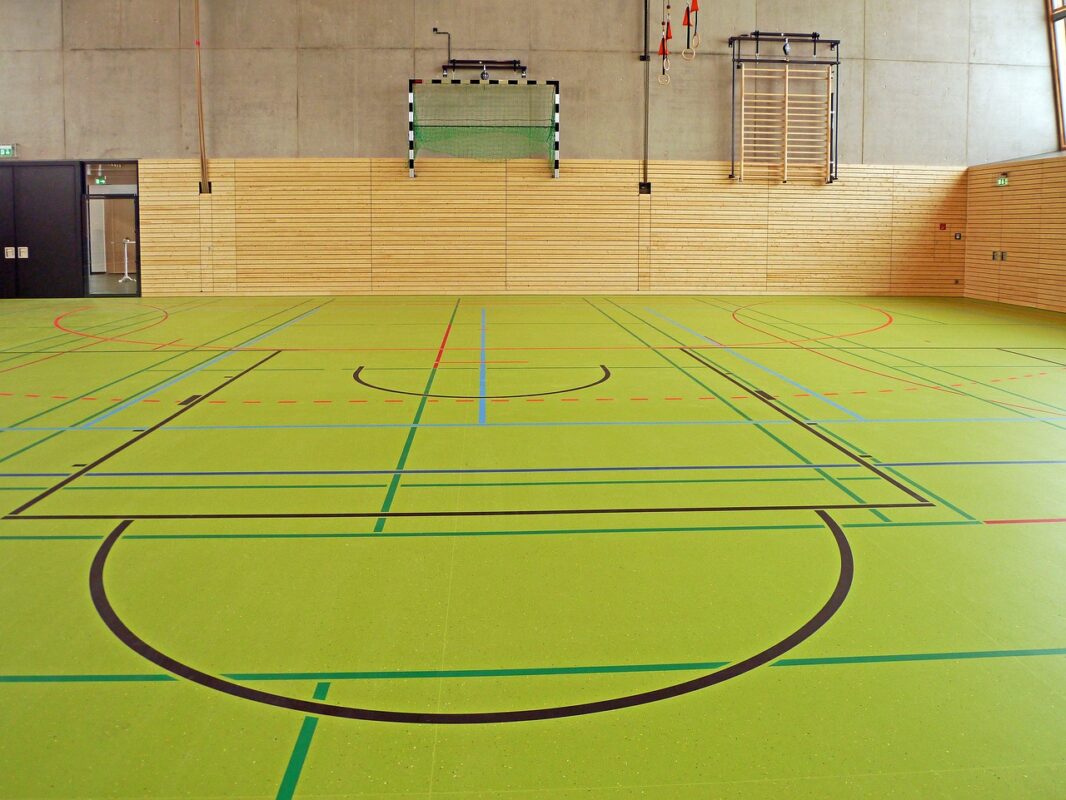 Sit-and-scoot boards stacked in a school gym