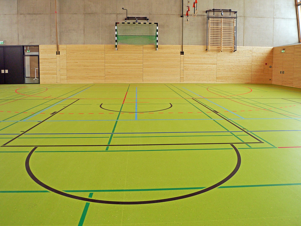 Sit-and-scoot boards stacked in a school gym